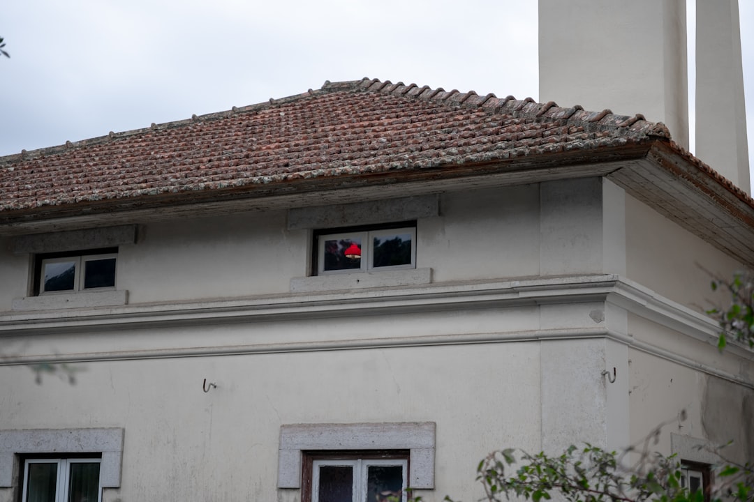 a-red-object-visible-in-a-window-of-a-building-mjeh8cuajw